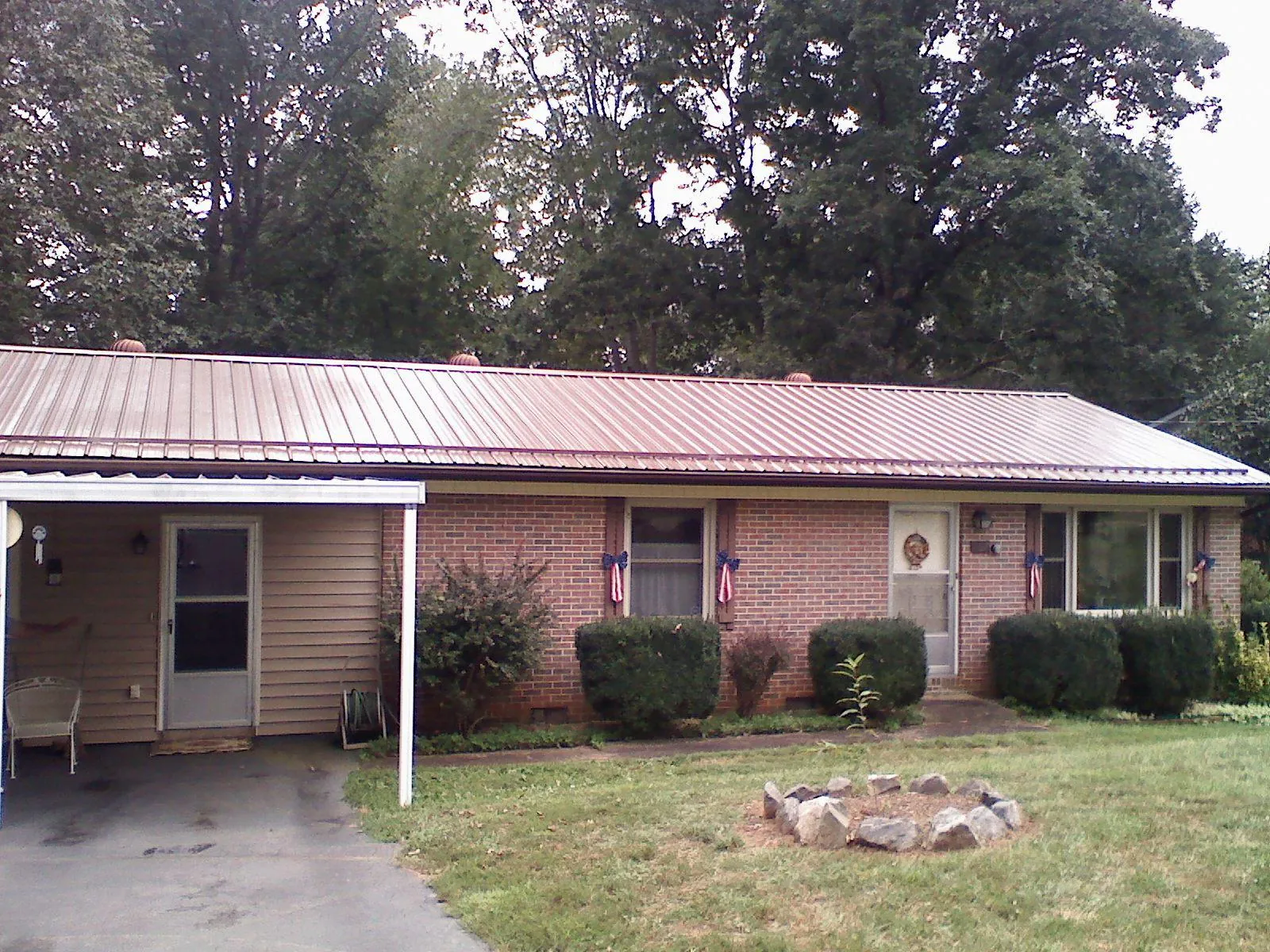 Bronze metal roof and carport on a brick ranch home — Roof Repair work by our crew in Troy